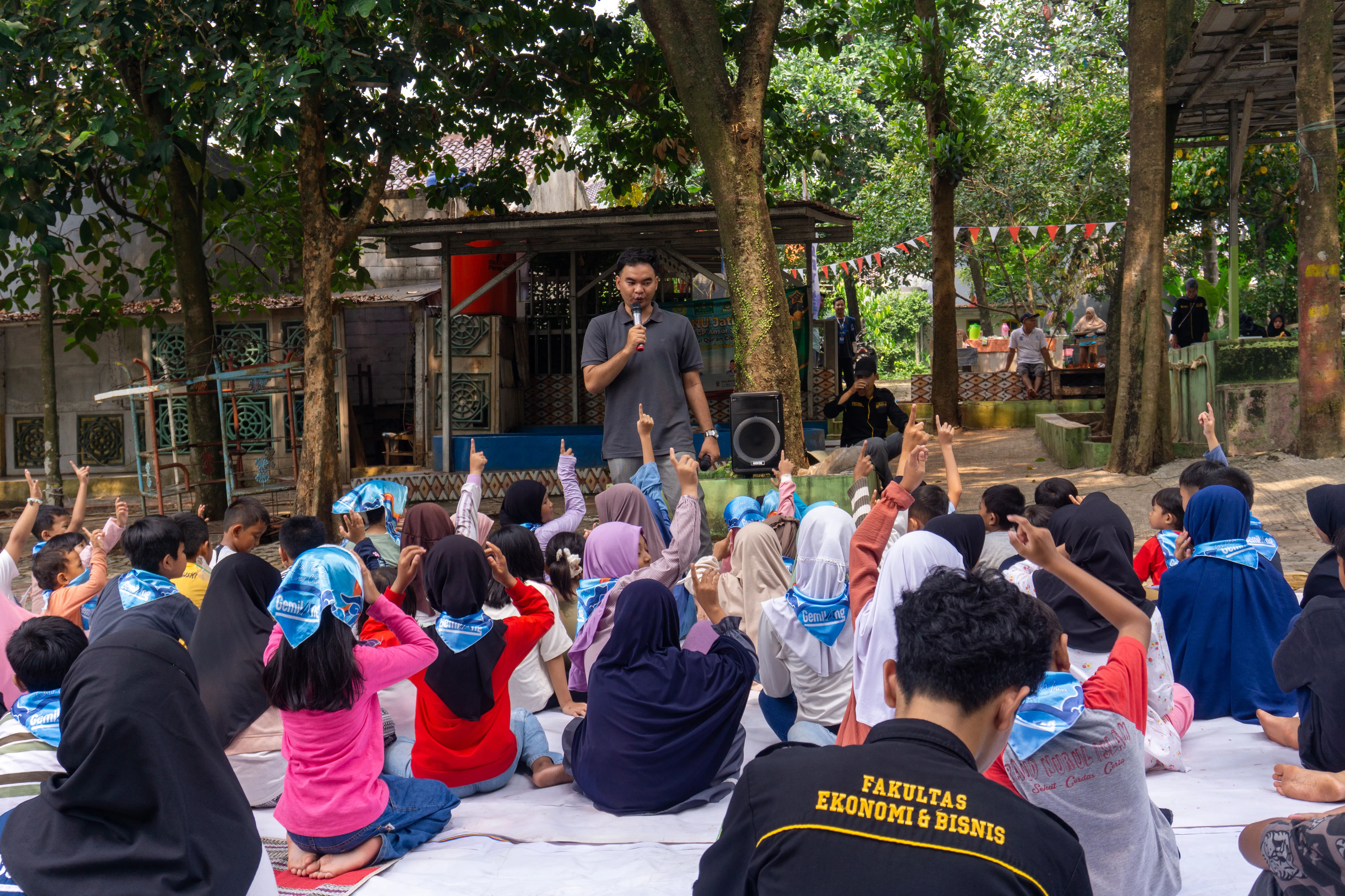 Anak-anak belajar di atas tikar di bawah pohon